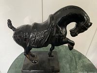 Full left-side view of black horse statue on base