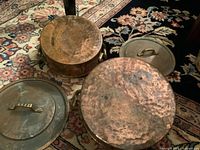 Pots and lids top view showing hammered copper and brass handles