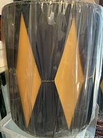 Front view of one lampshade showing dark panels and yellow diamond inserts under plastic