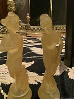 Front angled view of both resin statues standing on rug