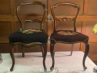 Front view of both antique balloon-back chairs showing upholstery and frames