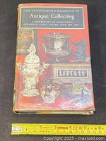 Front cover of hardcover book with dust jacket and ruler indicating length