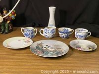Overview of three blue-and-white cups, three plates and bud vase