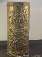 Full view of brass umbrella stand front, embossed figures