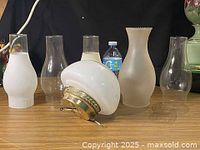 Group shot of ceiling lamp globe with brass fitter and five glass chimneys