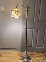 Full view of floor lamp showing height, post, base, cord