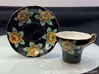 Teacup and saucer set front view showing floral design and gold accents