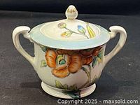 Front view of sugar bowl with floral motif, lid on