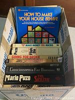 Box with all titles visible including How to Make Your House Behave on top