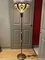 Full view of floor lamp showing base, column and stained glass shade