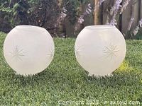Front view of two frosted glass globe shades showing starburst cut design