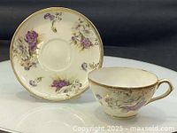 Cup and saucer front view showing floral design and gold trim