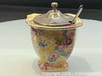 Front view of Royal Winton chintz jam pot with metal lid and spoon