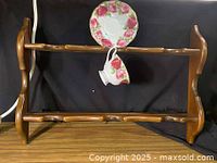 Front view of wooden rack showing saucer recesses and cup hook area