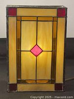 Front view of illuminated stained glass lamp showing geometric pattern and colors