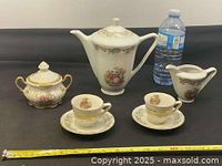 Full set displayed: teapot, sugar bowl, creamer, two cups, two saucers