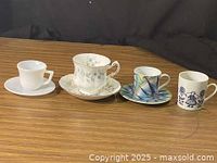 All four teacup and saucer pairs lined up on tabletop