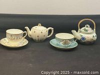 Group shot of both teapots and both teacup/saucer sets