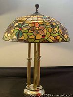 Full view of lamp showing stained glass shade and brass finish base