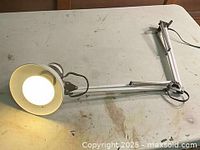 Full view of lamp extended on tabletop, light illuminated