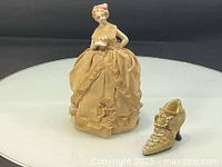 Porcelain figurine and ceramic shoe on display