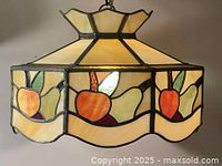 Side view of stained glass lamp highlighting fruit panels and scalloped edge