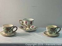 Front view of three teacups with saucers