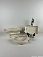 All three white ceramic Haeger pieces grouped: pedestal planter, rectangular tray, leaf dish