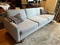 Front angled view of sofa with cushions and pillows visible