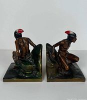 Front three-quarter view of both bookends showing figures and bases