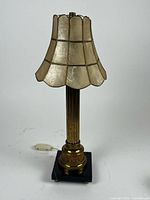 Full view of gold-tone column lamp with largest lampshade attached
