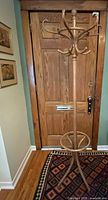 Full view of pine bentwood coat rack in front of door