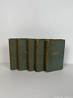 Front view of five green cloth volumes with gilt titles.