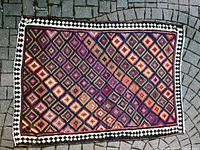 Full view of wool kilim rug on stone surface