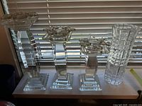 Front view of three crystal candlesticks and cut glass vase