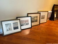 Four framed nautical prints leaning against wall