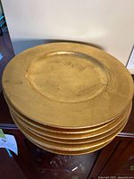 Stack of eight gold leaf charger plates