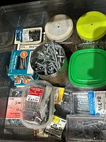Drawer with multiple boxes and tubs of screws, visible screw sizes and brands