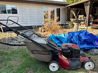 Left side view of red Craftsman mower with bag attached