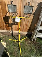 Front view of yellow tripod work light with two halogen heads