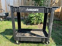 Front view showing Husky branding, two shelves, caster wheels