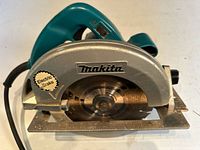 Left side view showing Makita logo, blade, electric brake decal