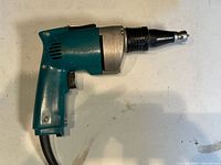Left side view of Makita drywall screwdriver showing teal housing and cord