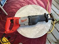 Left side view of Milwaukee Sawzall 6519-3 on table with part of yellow extension cord visible