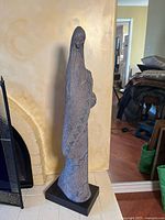 Full view of sculpture by fireplace on black base