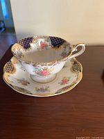 Teacup and saucer side view showing pattern and gold trim