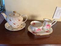 Teapot, saucer, creamer, sugar bowl and tray displayed together