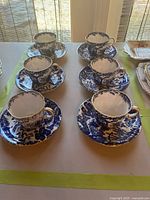 Full set of six teacup and saucer pairs displayed on table