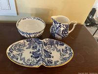 Overall view of creamer, sugar bowl and divided dish showing pattern and gilt rims