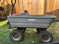 Left side view of Rubbermaid dump wagon showing frame, wheels, handle and branding